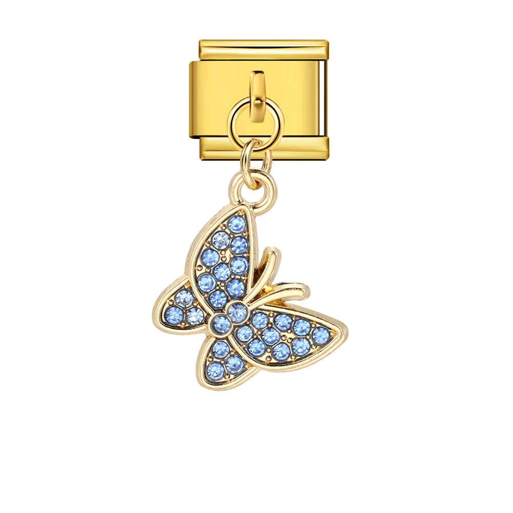 Gold butterfly charm with blue stones on a white background