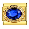 Gold charm with a blue gemstone on a white background