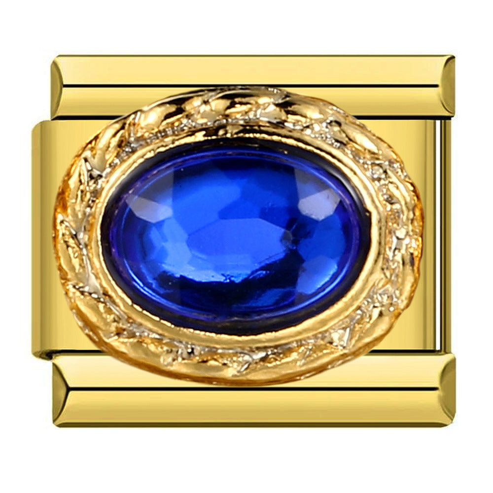 Gold charm with a blue gemstone on a white background