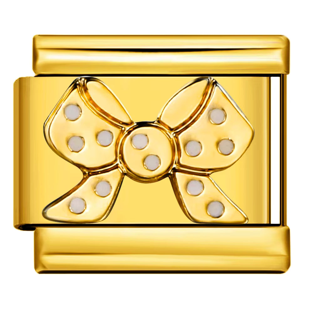 Gold bow-shaped charm with polka dots on a white background