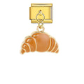 Gold charm with a croissant design on a white background
