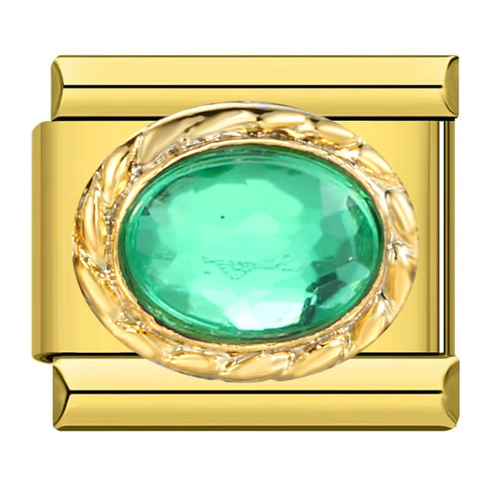 Gold charm with a green gemstone on a white background