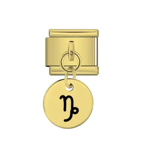 Gold charm with a black astrological symbol on a white background