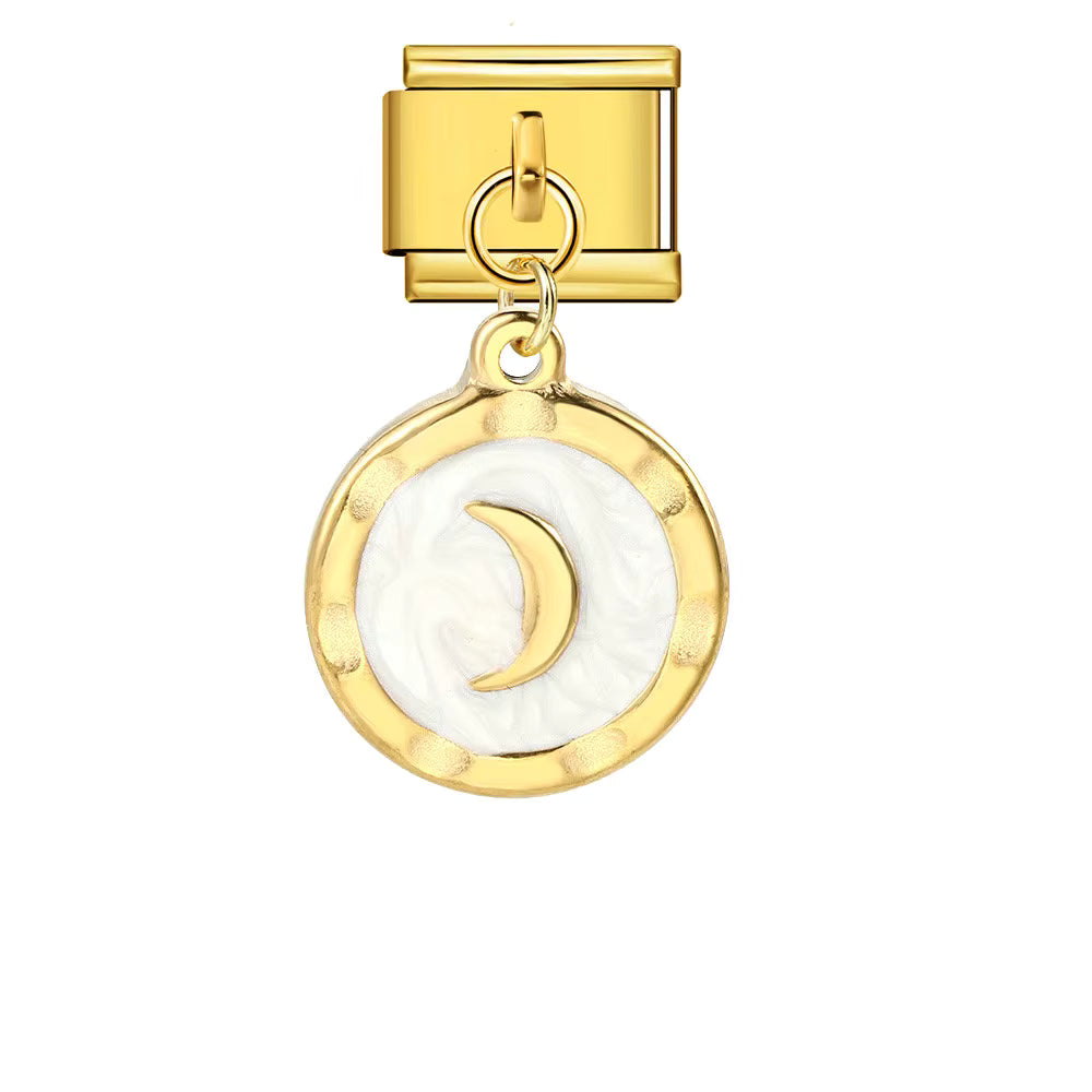 Gold charm with a white crescent moon design on a white background