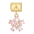 Gold charm with pink floral design on a white background