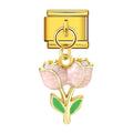 Gold charm with pink flower and green leaves on a white background