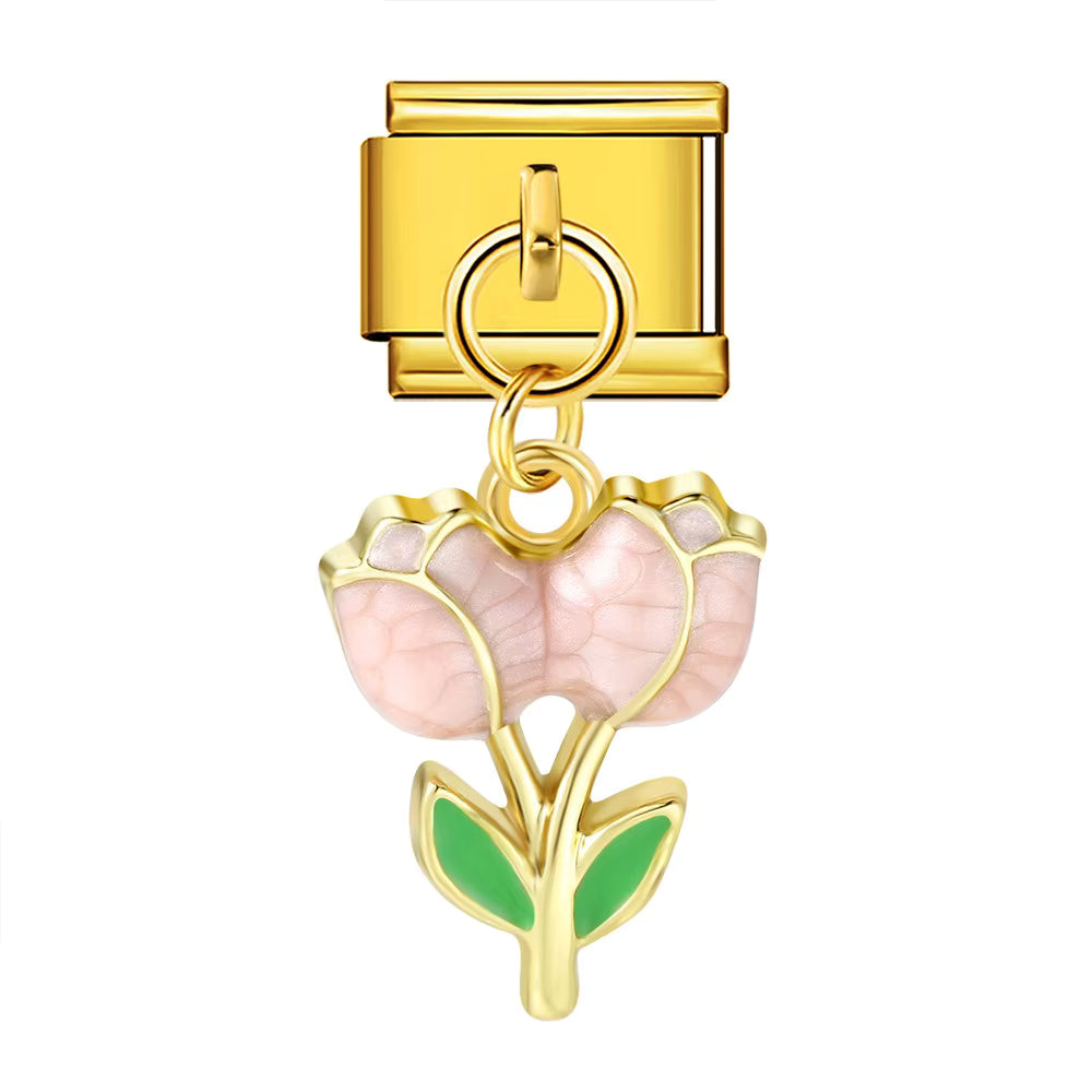 Gold charm with pink flower and green leaves on a white background