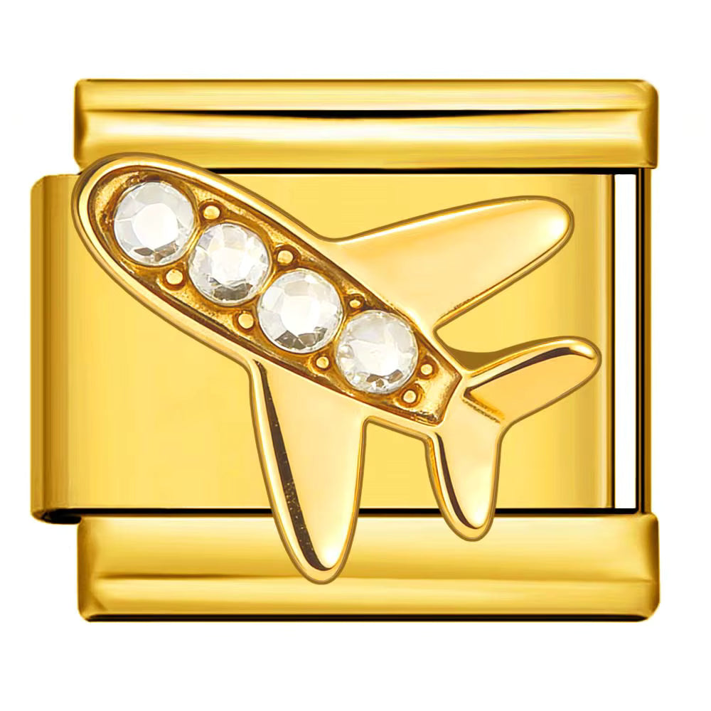 Gold airplane-shaped object with embedded crystals on a white background