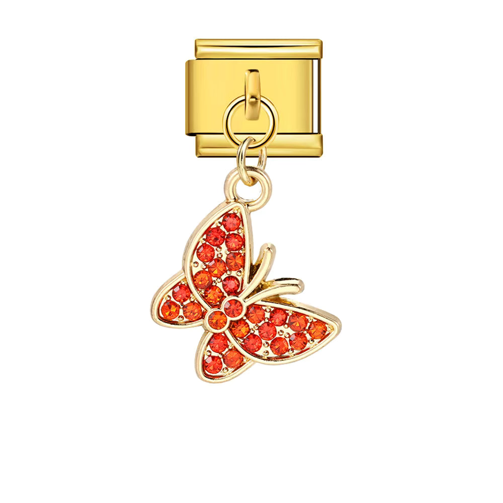 Gold butterfly charm with red gemstones on a white background