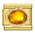 Gold charm with a large yellow gemstone on a white background