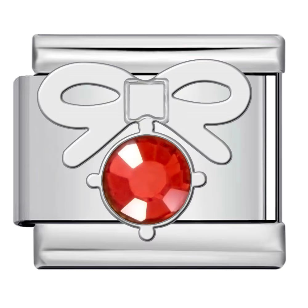 Silver bow charm with a red gemstone on a white background