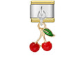 Gold and silver charm with red cherries and a green leaf on a white background