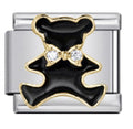 silver charm with black and gold design and clear stones on a white background