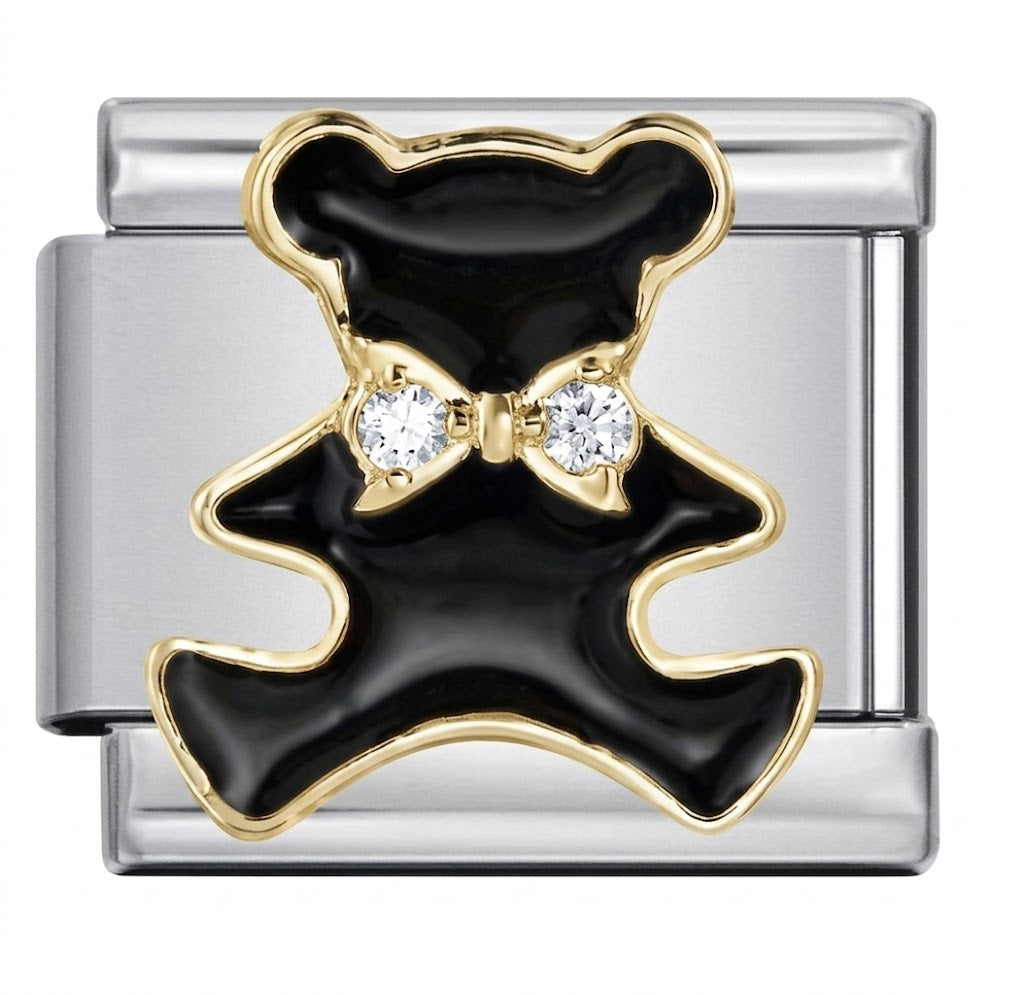 silver charm with black and gold design and clear stones on a white background
