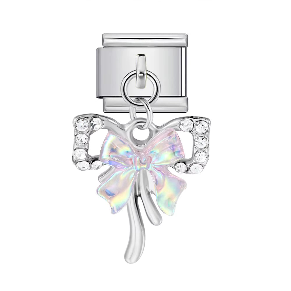 Silver charm with a bow-shaped crystal on a white background