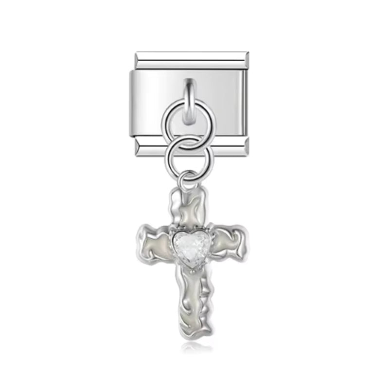 Silver cross charm with a crystal heart detail on a white background