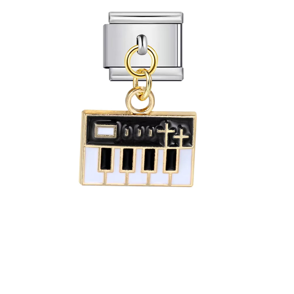 Piano key charm with gold and silver accents on a white background