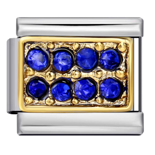 Jewelry charm with blue gemstones and gold accents on a white background