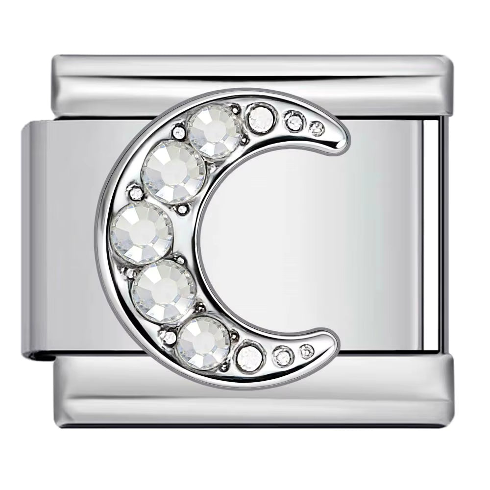 Silver charm with a crescent moon design and embedded crystals on a white background