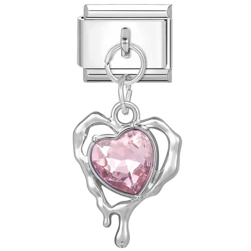 Silver charm with a pink heart-shaped gem on a white background