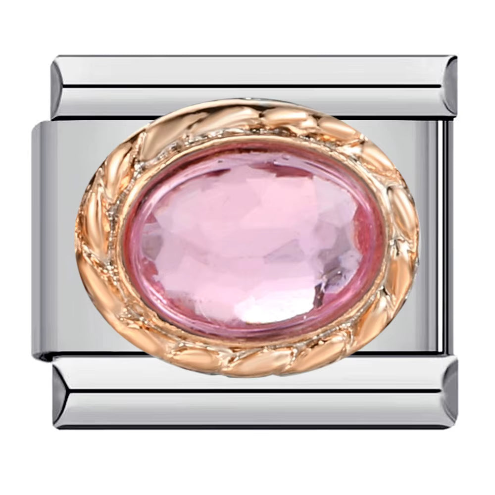 Silver charm with pink gemstone and gold accents on a white background
