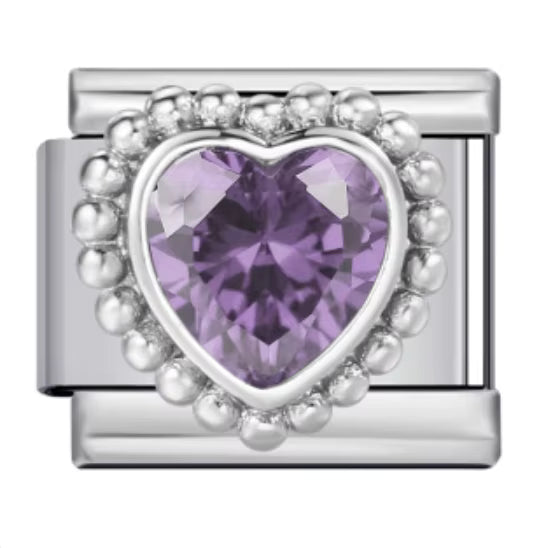 Silver charm with a purple heart-shaped gemstone on a white background
