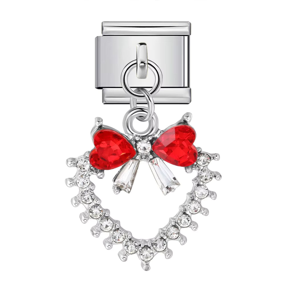 Jewelry charm with red heart-shaped bow and clear stones on a white background