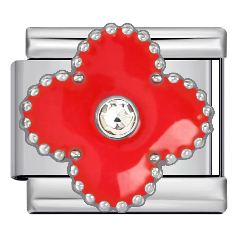 Silver charm with a red clover-shaped center and small stones around on a white background