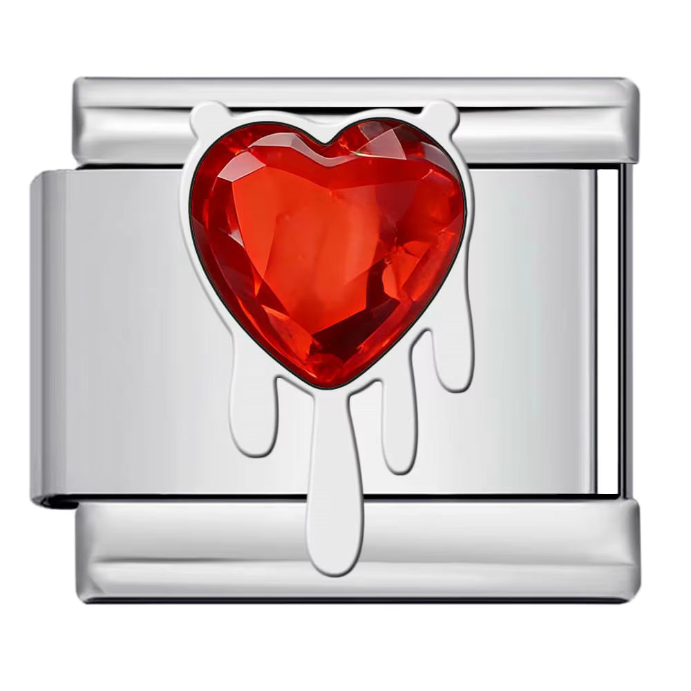 Silver charm with a red heart-shaped gem on a white background