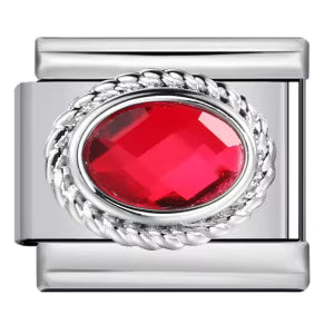 Silver charm with a red gemstone on a white background