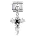 Silver cross charm with black gemstone on a white background