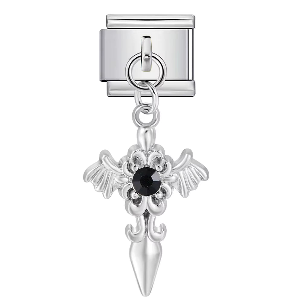 Silver cross charm with black gemstone on a white background