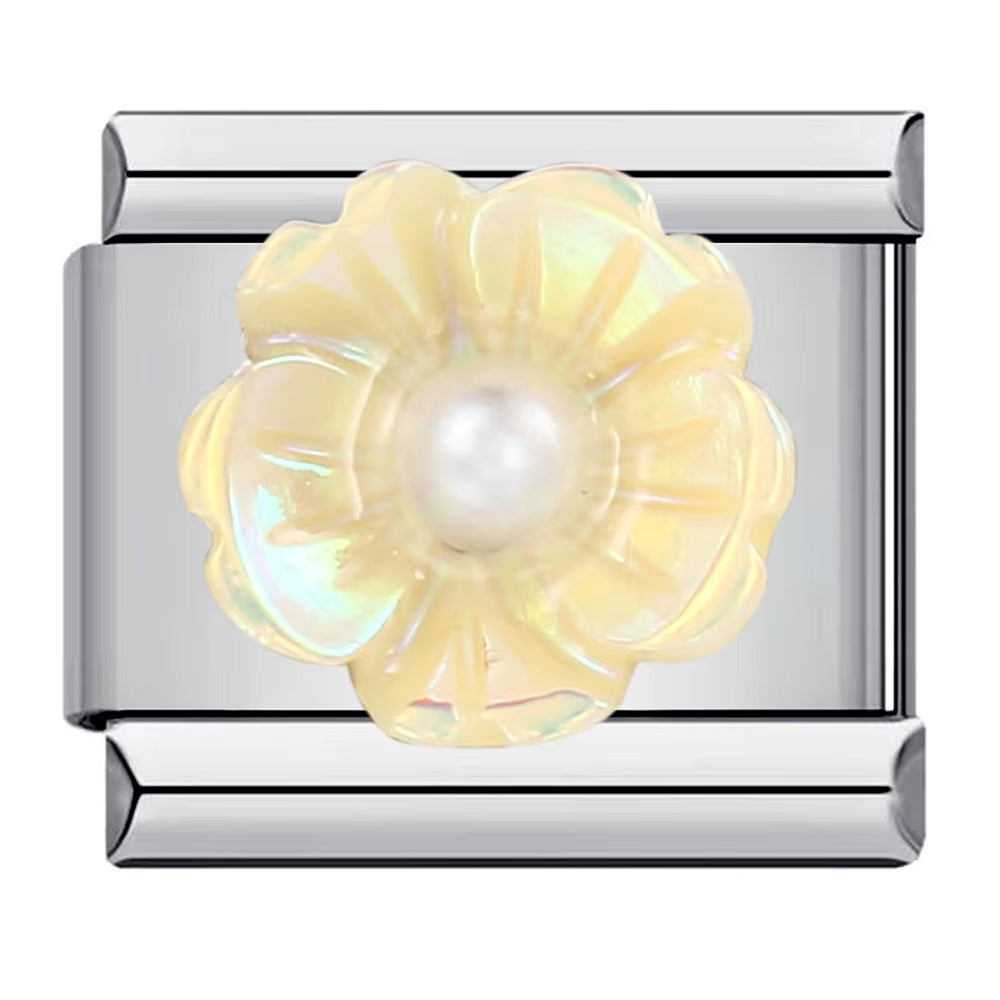 Silver charm with a yellow flower and pearl center on a white background